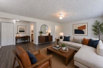 Webster apartment for rent - A living room with a brown leather chair and a white couch.