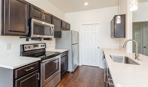 Avon apartment for rent - kitchen with espresso cabinets, stainless appliances, and laminate plank floors
