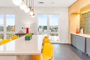 Portland apartment for rent - a dining room with yellow chairs and a long white table