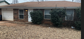 Guthrie house for rent - A brick house with a white garage door and a white door.