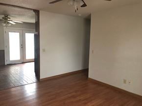 Guthrie house for rent - A room with a ceiling fan and a door leading to another room.