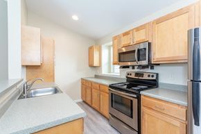 Farmington apartment for rent - A kitchen with wooden cabinets and a black stove top oven.