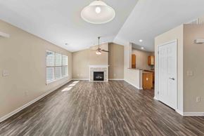 Farmington apartment for rent - A spacious living room with wood flooring and a fireplace.
