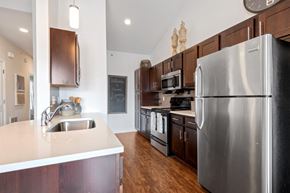 North Chili apartment for rent - a kitchen with stainless steel appliances and wooden cabinets