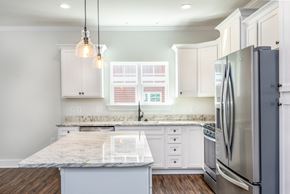 Spartanburg apartment for rent - a white kitchen with stainless steel appliances and marble counter tops