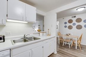 Grand Rapids apartment for rent - a kitchen with white cabinets and a dining room with a table and chairs