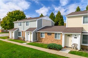 Elyria townhouse for rent - a row of houses in a neighborhood with a sidewalk and grass