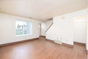 Elyria townhouse for rent - the living room and dining room of an apartment with wood flooring and a window