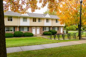 Medina townhouse for rent - a house with a sidewalk in front of a lawn and trees