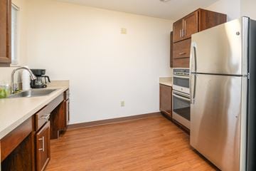 Medina townhouse for rent - a kitchen with stainless steel appliances and wooden flooring and a refrigerator
