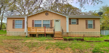 Guthrie house for rent - A small house with a porch and a green door.