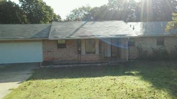 Harrah house for rent - A house with a grey roof and a white garage door.