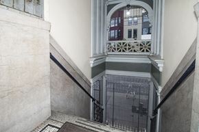San Francisco apartment for rent - A staircase with a metal railing and a window with a view of a building in the background.