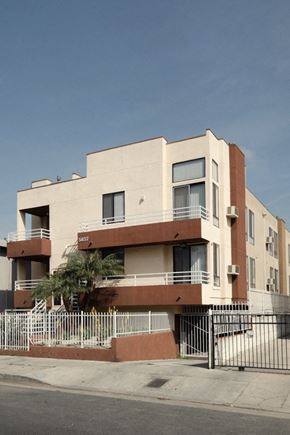 Los Angeles apartment for rent - A modern building with a balcony and a gate in front.
