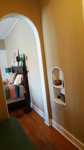 Jonesboro apartment for rent - an arched door way into a room with a bed and shelves