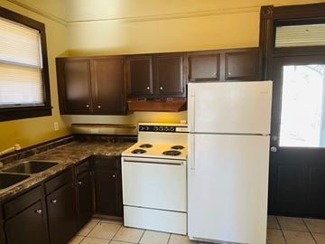 Jonesboro house for rent - a kitchen with white appliances and black cabinets