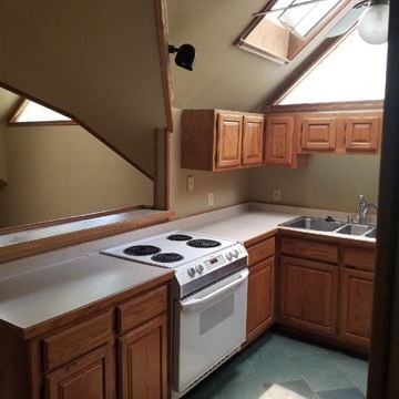 Jonesboro apartment for rent - A kitchen with a white stove top oven and wooden cabinets.