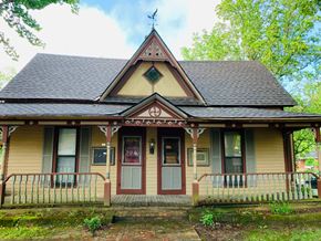 Jonesboro apartment for rent - a yellow house with a steep roof and a porch