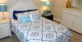 Greensboro apartment for rent - a bedroom with a bed and a blue and white comforter