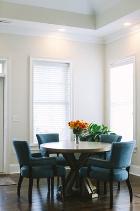 Greensboro apartment for rent - a dining room table with blue chairs and a vase of flowers