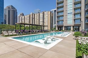 Atlanta apartment for rent - a swimming pool with lounge chairs in front of an apartment building