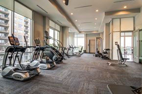 Atlanta apartment for rent - a gym with cardio equipment on the floor and large windows