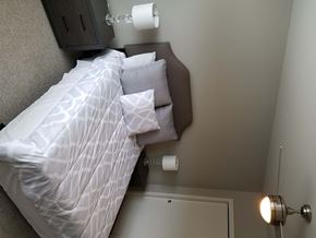 Cleveland apartment for rent - a bed in a small room with a white comforter and pillows