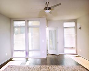 Cleveland apartment for rent - an empty living room with a ceiling fan and windows
