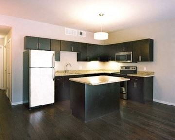 Cleveland apartment for rent - a kitchen with black cabinets and a white refrigerator