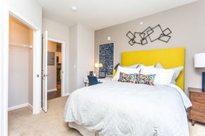 Brighton apartment for rent - a bedroom with a yellow headboard and a white bed
