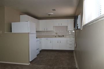 Olathe apartment for rent - A kitchen with white cabinets and a brown floor.