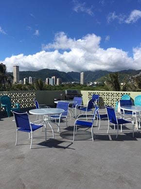 Honolulu apartment for rent - A table with blue chairs is set up on a patio.