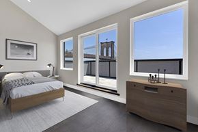 Ny apartment for rent - A bedroom with a large bed and a view of a bridge through the windows.