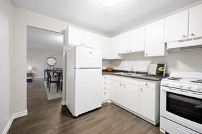 London apartment for rent - A white kitchen with a refrigerator, oven, and cabinets.
