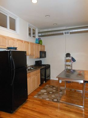 Chicago apartment for rent - a kitchen with a black refrigerator and a table