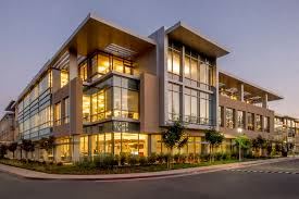 Phoenix apartment for rent - A modern building with large windows and balconies is illuminated at dusk.