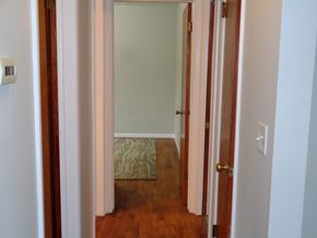 Kalamazoo house for rent - a small hallway with a door to a bedroom and a rug on the floor