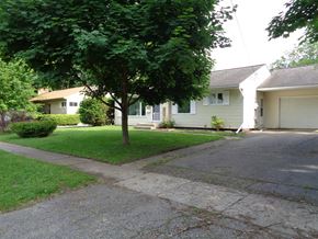 Kalamazoo house for rent - a white house on a street with a sidewalk and trees