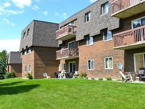 London apartment for rent - a large brick apartment building with balconies and a lawn