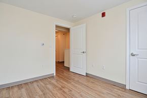 Holyoke apartment for rent - a bedroom with white walls and wood flooring and a door to a closet