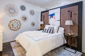 Dallas apartment for rent - a bedroom with a large bed and sun mirrors on the wall