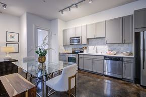 Dallas apartment for rent - a kitchen and dining room with stainless steel appliances and a glass table