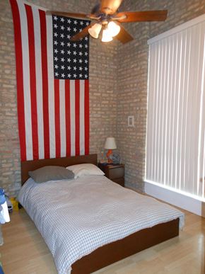 Chicago apartment for rent - a bedroom with a bed and an flag on the wall