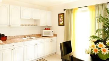 Tampa apartment for rent - A kitchen with white cabinets and a black chair.