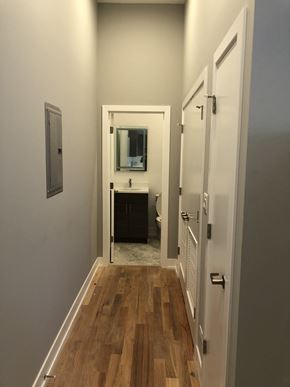 Chicago apartment for rent - a small hallway with a door to a bathroom with a sink and a mirror