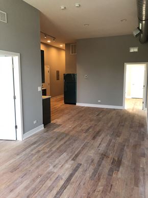 Chicago apartment for rent - an empty living room with a wooden floor and grey walls