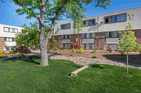 Pueblo apartment for rent - the exterior of an apartment building with grass and trees
