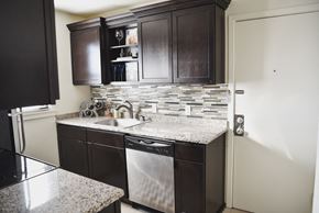 Tulsa apartment for rent - a kitchen with dark wood cabinets and granite counter tops and a sink