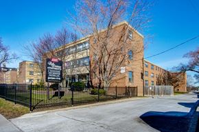 Scarborough apartment for rent - a large brick building with a sign in front of a fence