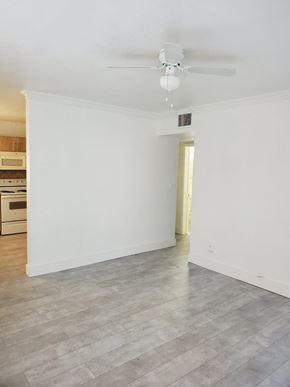 North Miami Beach apartment for rent - A room with a ceiling fan and a light hanging from it.